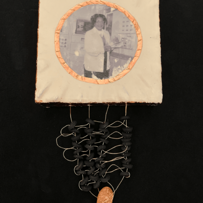 A close-up of a mixed media artwork featuring historic figure Mary Jackson on a square panel made of white encaustic and copper. Woven copper wire and beads hang below each piece.