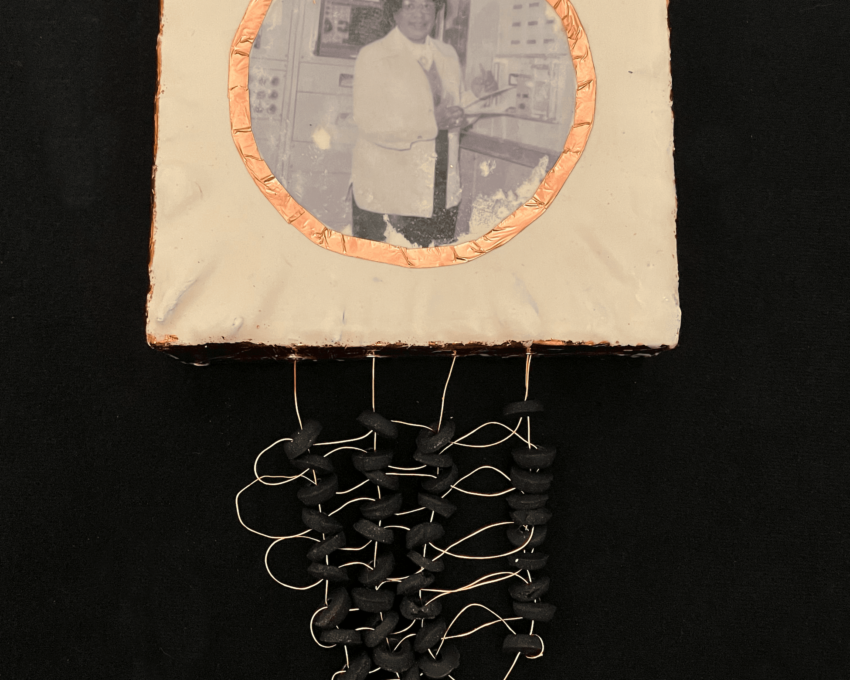 A close-up of a mixed media artwork featuring historic figure Mary Jackson on a square panel made of white encaustic and copper. Woven copper wire and beads hang below each piece.
