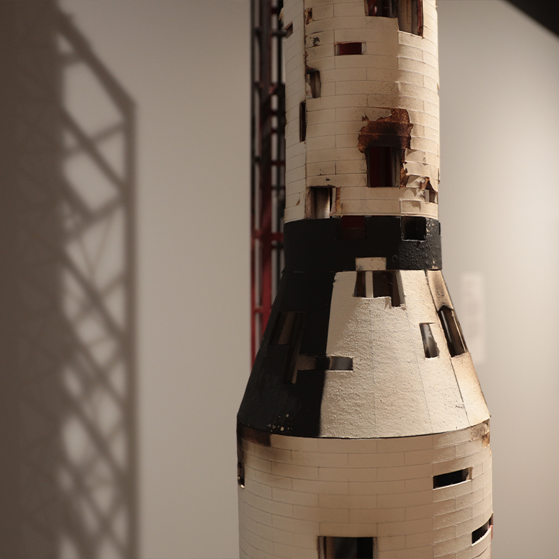 A section of a rocket sculpture made of painted wood.